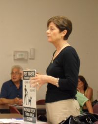 Clean Streets Committee Co-Chair Naomi Paul holds a “Clean Up” sign.