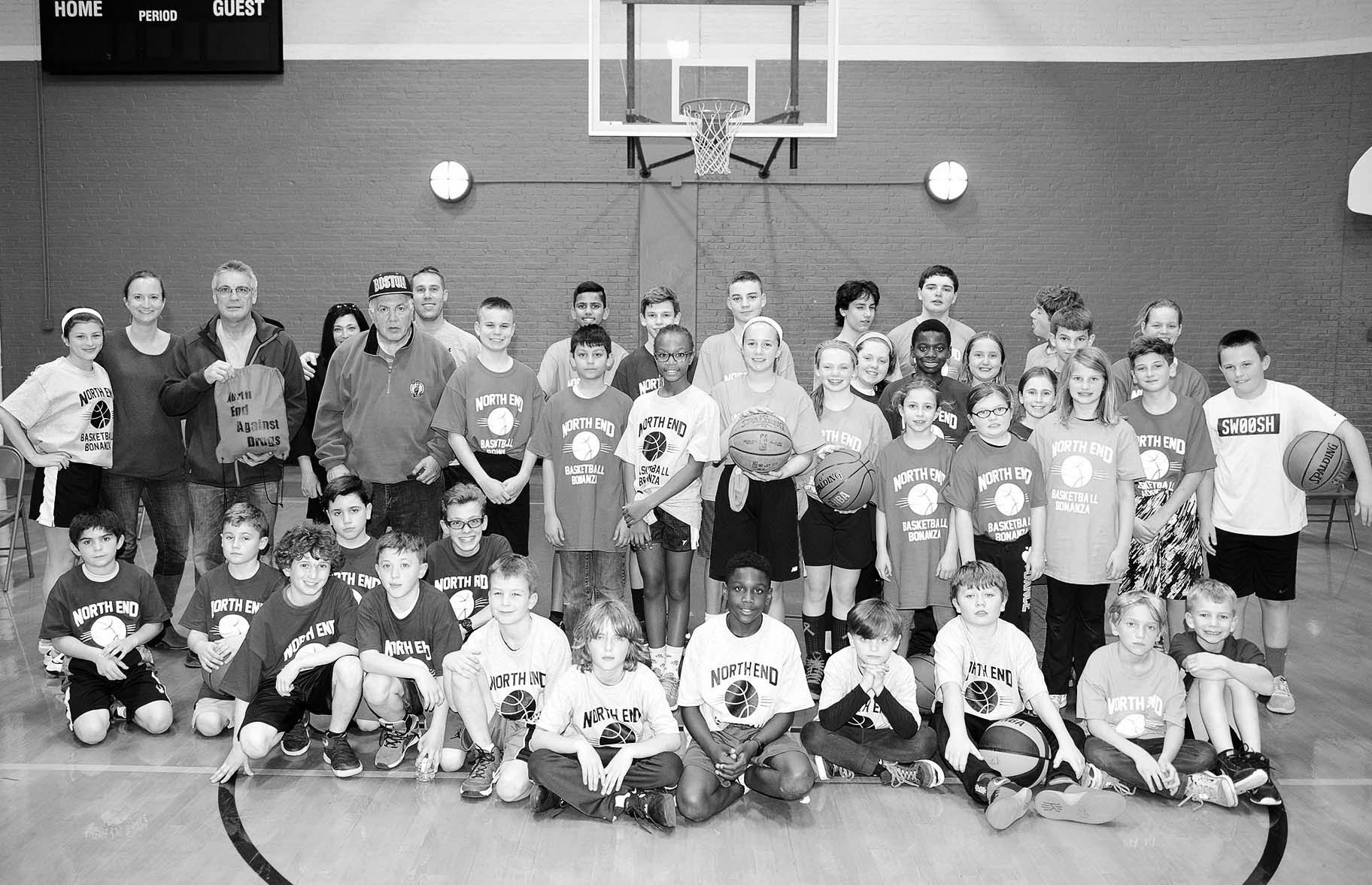 Children, organizers and coaching staff stood together in the Nazzaro Center before the start of the basketball clinic.